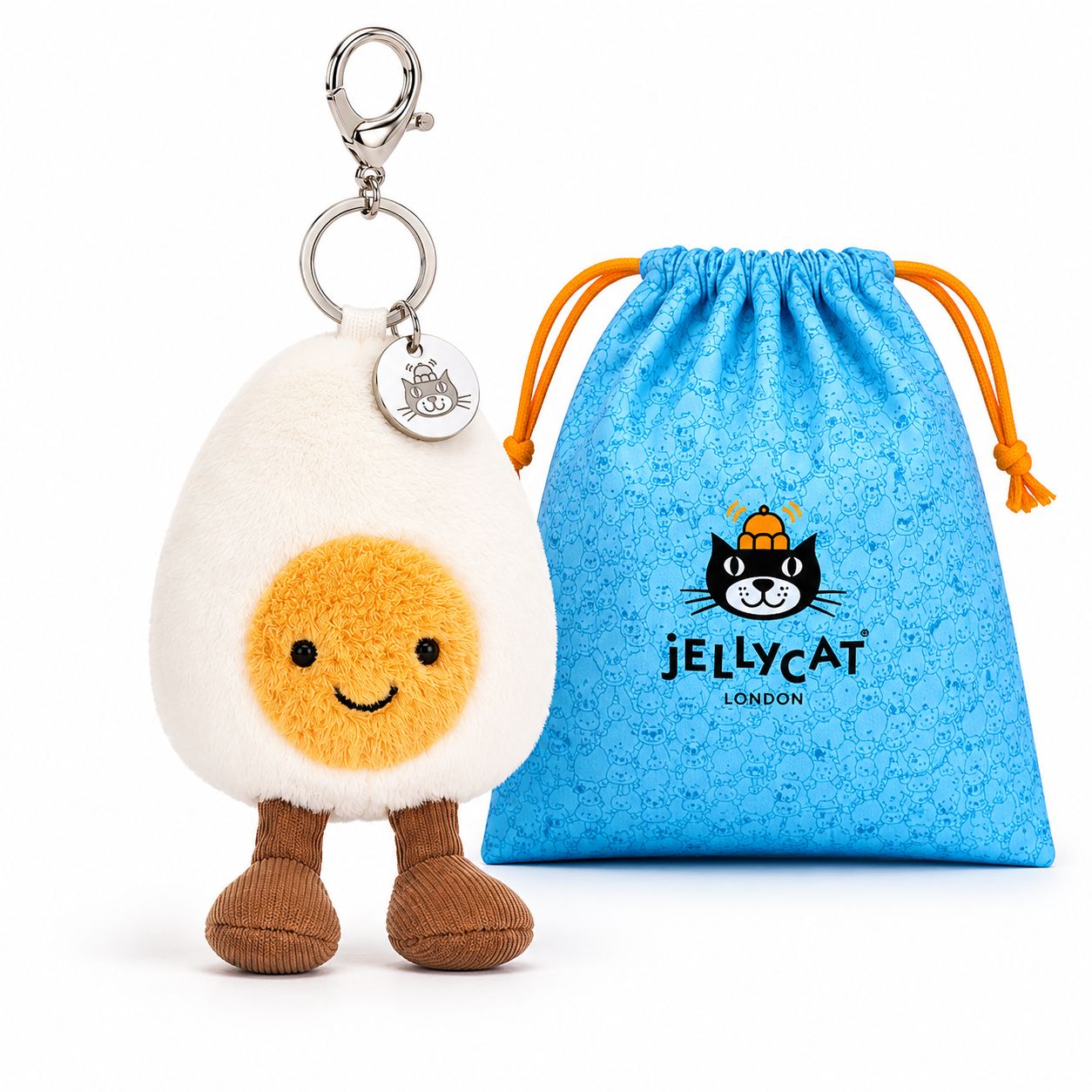 Plush toy resembling a boiled egg with a keychain and branded blue pouch on a white background